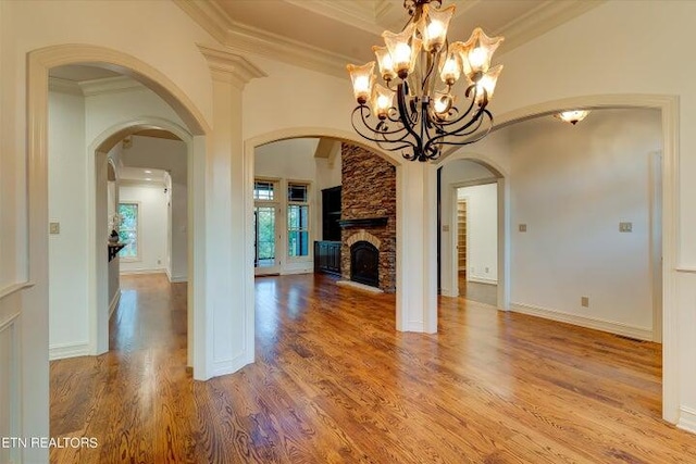 unfurnished living room featuring ornamental molding, wood-type flooring, and a fireplace