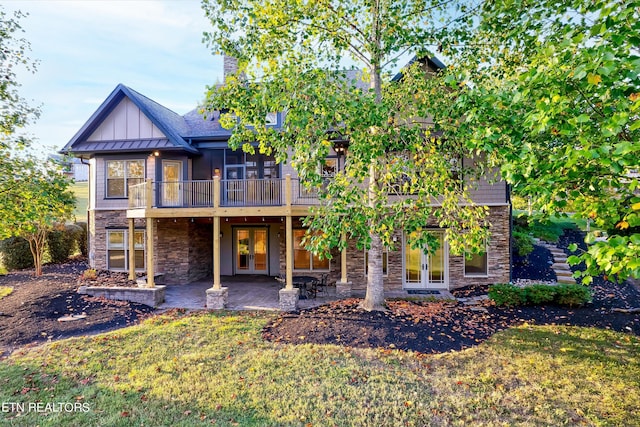 back of house featuring french doors, a patio area, and a lawn