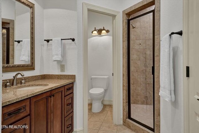 bathroom featuring tile patterned flooring, toilet, vanity, and walk in shower