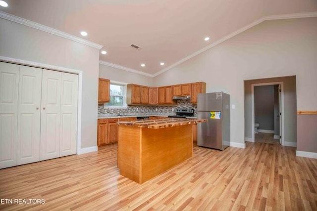 kitchen with a center island, stainless steel appliances, light hardwood / wood-style flooring, and crown molding