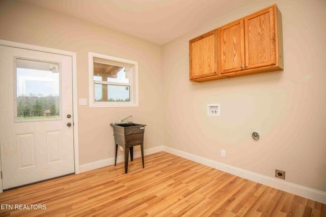 laundry area with washer hookup, electric dryer hookup, light hardwood / wood-style floors, and cabinets