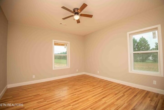 unfurnished room featuring ceiling fan, light wood-type flooring, and a wealth of natural light