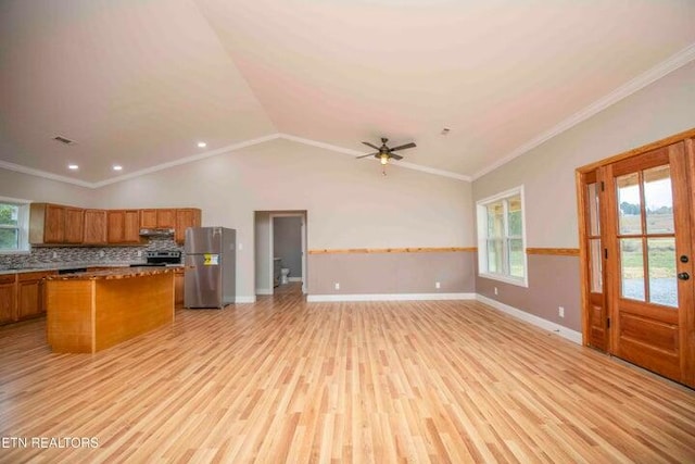 kitchen with a center island, ornamental molding, appliances with stainless steel finishes, and light hardwood / wood-style flooring