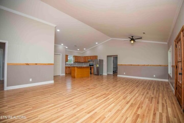 unfurnished living room with ceiling fan, light hardwood / wood-style floors, ornamental molding, and vaulted ceiling