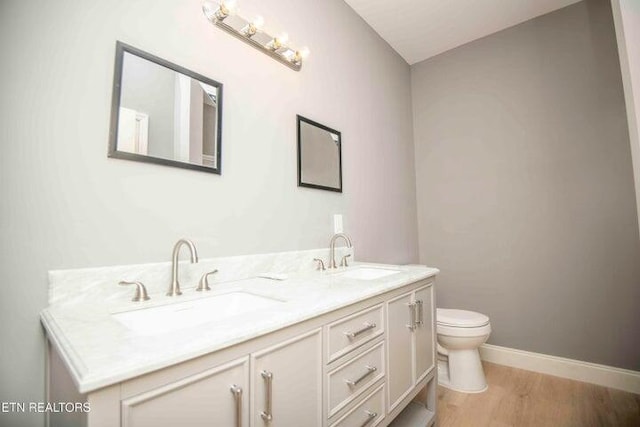 bathroom with vanity, hardwood / wood-style flooring, and toilet