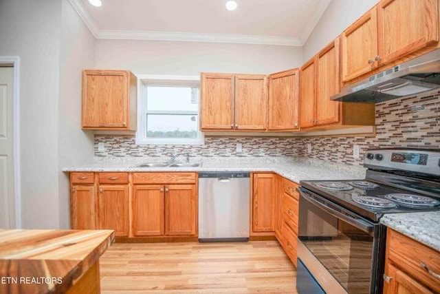 kitchen featuring sink, ornamental molding, light wood-type flooring, appliances with stainless steel finishes, and tasteful backsplash