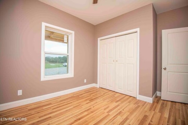 unfurnished bedroom with light hardwood / wood-style floors and a closet