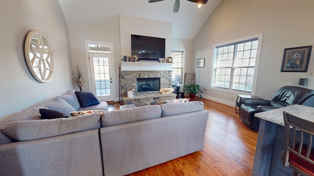 living room with a fireplace, hardwood / wood-style flooring, high vaulted ceiling, and ceiling fan