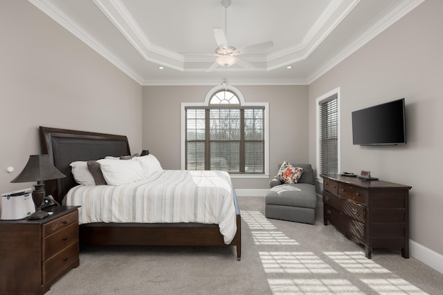 carpeted bedroom featuring a tray ceiling, ceiling fan, and ornamental molding