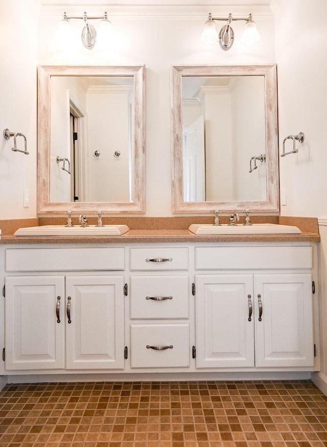 full bathroom featuring double vanity, crown molding, and a sink