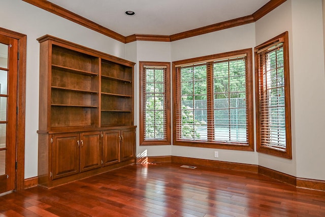 unfurnished living room with a healthy amount of sunlight, crown molding, and dark hardwood / wood-style floors