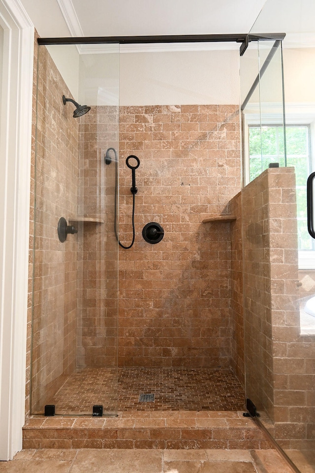 bathroom featuring a shower with shower door and crown molding