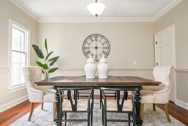 dining space with crown molding, baseboards, and wood finished floors