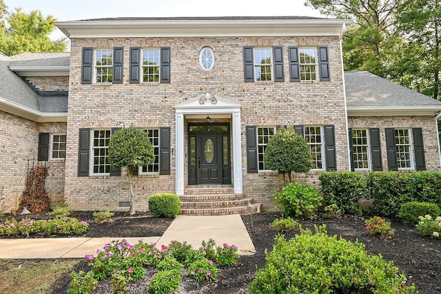 view of front of house featuring brick siding and a shingled roof