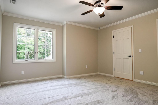 empty room featuring baseboards, visible vents, light colored carpet, ceiling fan, and ornamental molding