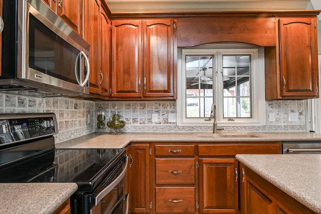 kitchen with tasteful backsplash, electric stove, stainless steel microwave, light countertops, and a sink