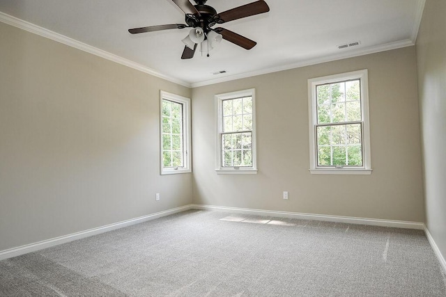 spare room featuring ornamental molding, baseboards, visible vents, and carpet flooring