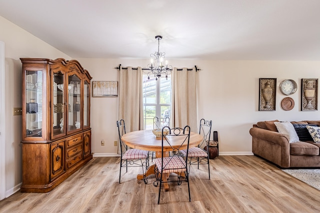 dining space with a notable chandelier and light wood-type flooring