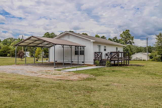 rear view of house featuring a yard, a carport, and a wooden deck