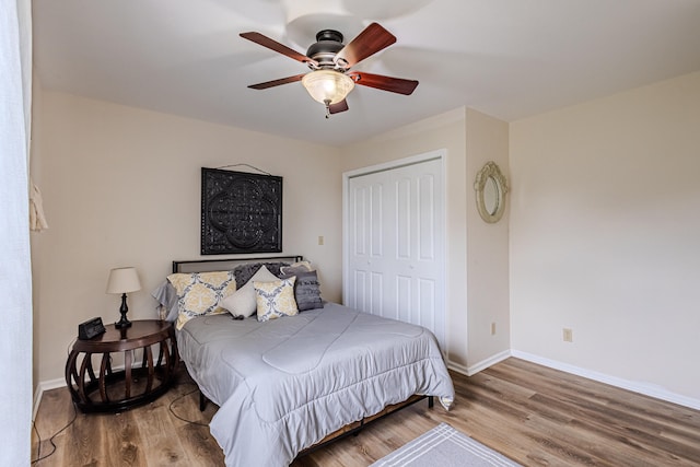 bedroom with ceiling fan, a closet, and wood-type flooring