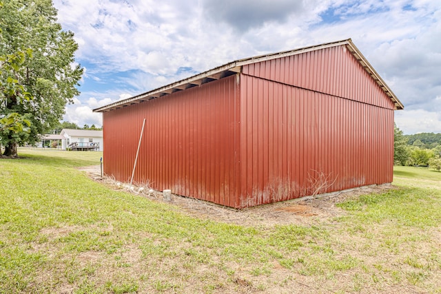 view of home's exterior with a lawn and an outdoor structure