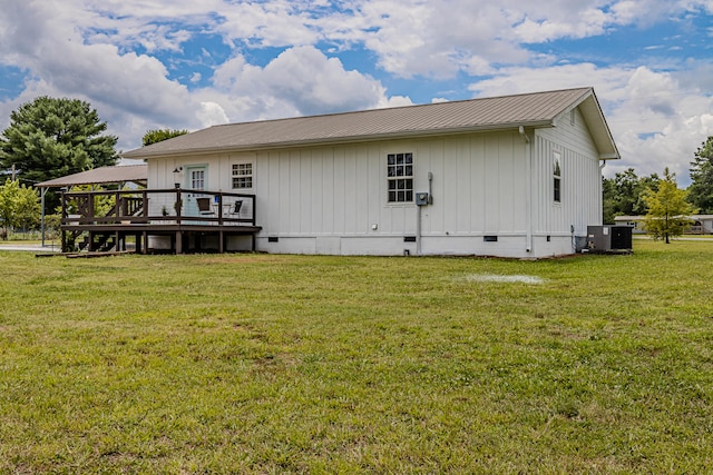 back of property with central air condition unit, a wooden deck, and a yard