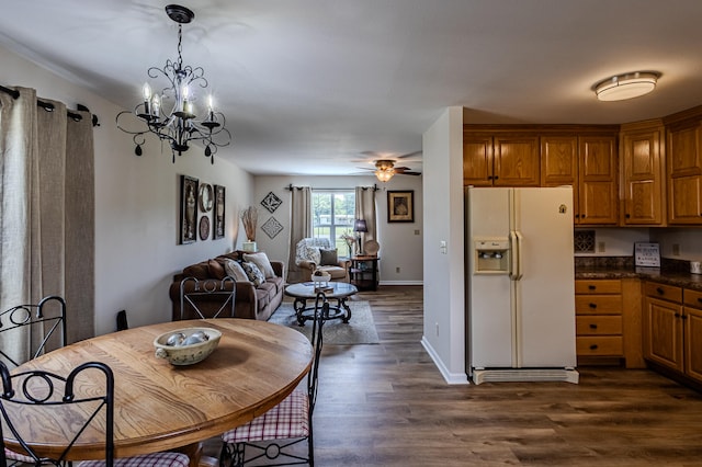 dining area with ceiling fan with notable chandelier and dark wood-type flooring