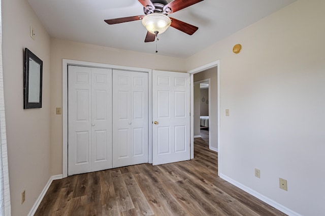 unfurnished bedroom featuring ceiling fan, wood-type flooring, and a closet