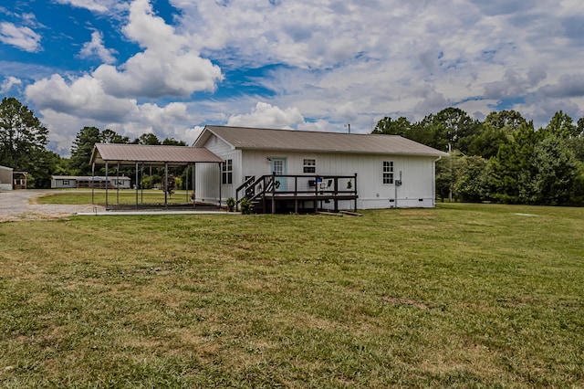 rear view of property with a lawn, a deck, and a carport