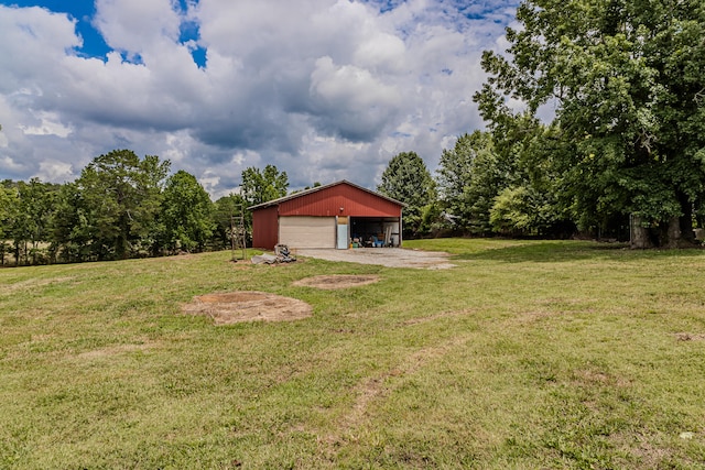 view of yard with a garage and an outbuilding