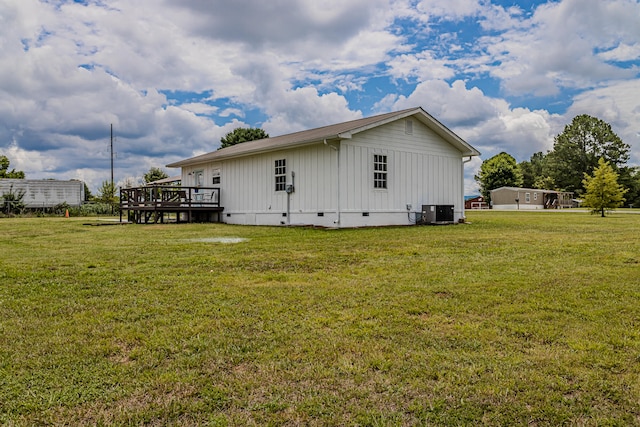 view of side of property with a lawn, a deck, and central air condition unit