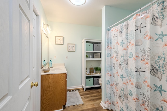 bathroom with hardwood / wood-style flooring, vanity, toilet, and a shower with curtain