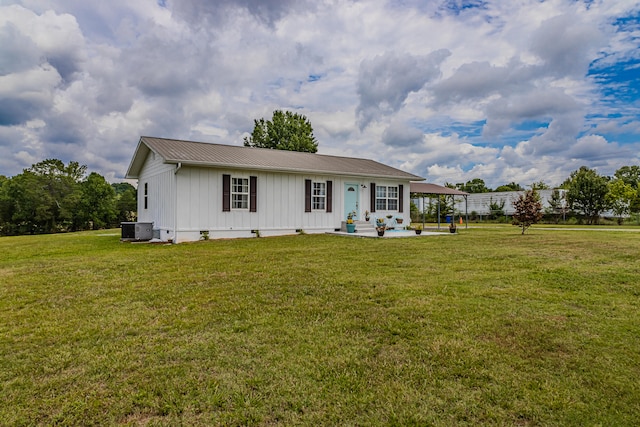 view of front of house featuring a carport, cooling unit, and a front lawn