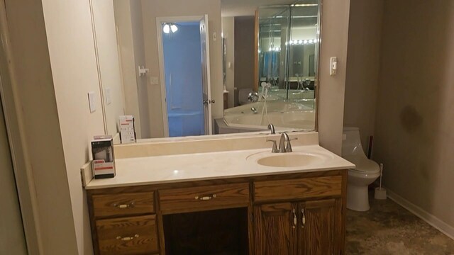 bathroom with a tub, vanity, and toilet