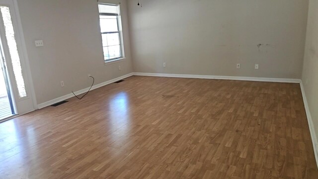 unfurnished room with hardwood / wood-style flooring