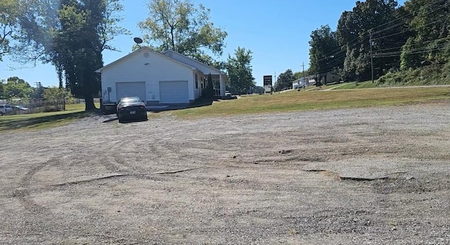 view of property exterior with a garage, a yard, and an outbuilding