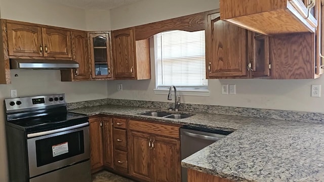 kitchen with light stone counters, sink, and stainless steel appliances