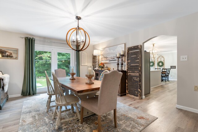 364 Hidden Oaks Trl, Cleveland, TN 37312 - dining room featuring a chandelier, arched walkways, and light wood-style floors