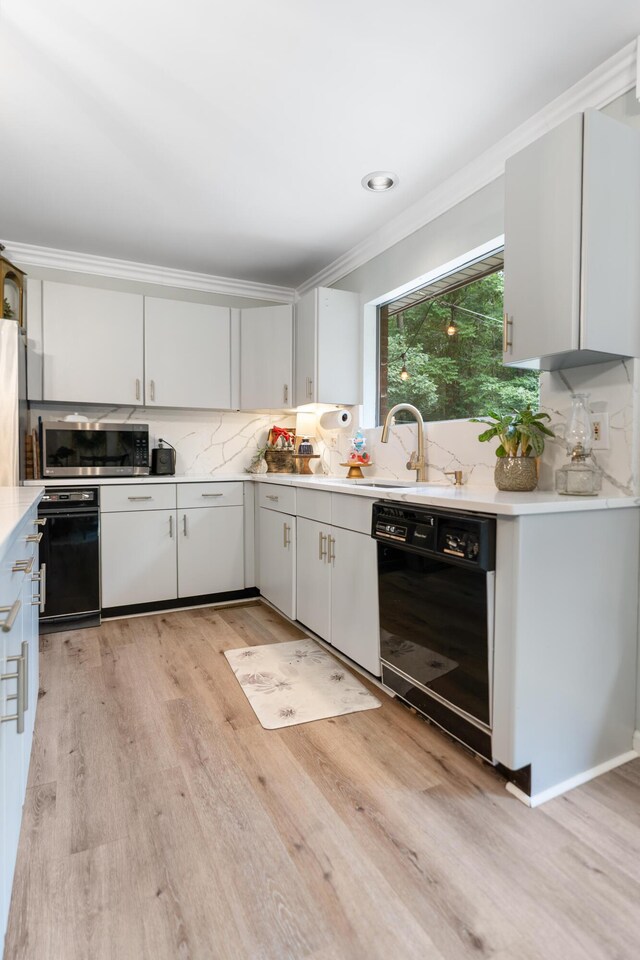 364 Hidden Oaks Trl, Cleveland, TN 37312 - kitchen with dishwasher, stainless steel microwave, ornamental molding, light countertops, and light wood finished floors