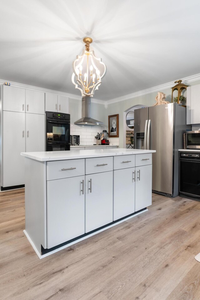 364 Hidden Oaks Trl, Cleveland, TN 37312 - kitchen with wall chimney range hood, appliances with stainless steel finishes, a chandelier, light countertops, and light wood finished floors
