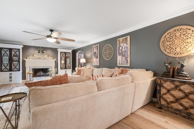 364 Hidden Oaks Trl, Cleveland, TN 37312 - living area with ceiling fan, light wood finished floors, crown molding, a premium fireplace, and arched walkways