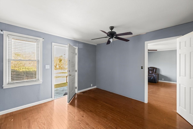 spare room featuring ceiling fan, wood-type flooring, and crown molding