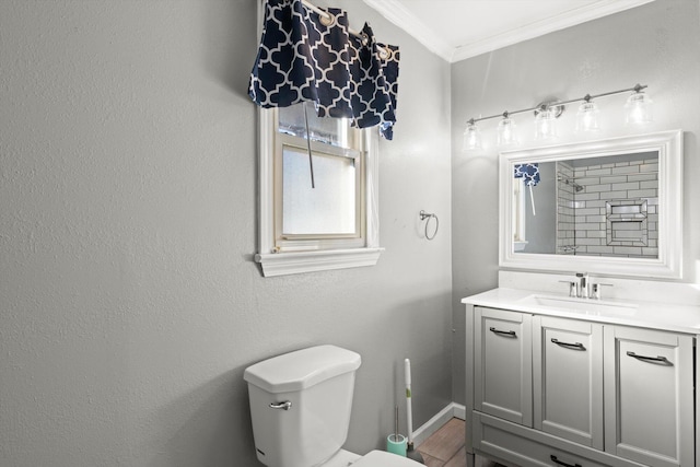 bathroom with toilet, vanity, and ornamental molding