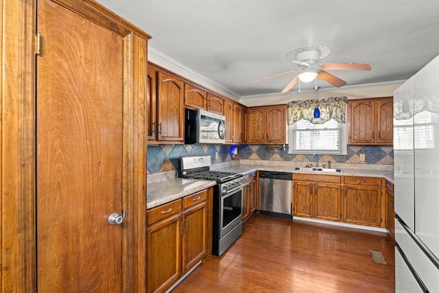 kitchen featuring ceiling fan, sink, dark wood-type flooring, stainless steel appliances, and tasteful backsplash