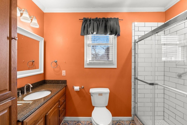 bathroom featuring vanity, toilet, a shower with door, and crown molding