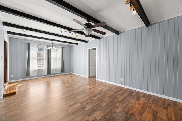 unfurnished room with rail lighting, ceiling fan with notable chandelier, wood-type flooring, beamed ceiling, and wood walls