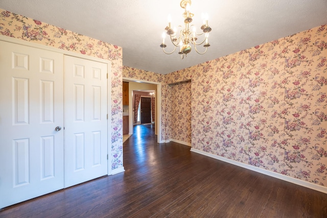139 County Road 147, Riceville, TN 37370 - unfurnished dining area with baseboards, wallpapered walls, dark wood finished floors, and a chandelier
