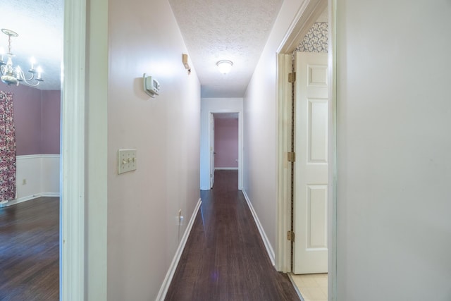 139 County Road 147, Riceville, TN 37370 - hallway featuring an inviting chandelier, baseboards, a textured ceiling, and wood finished floors