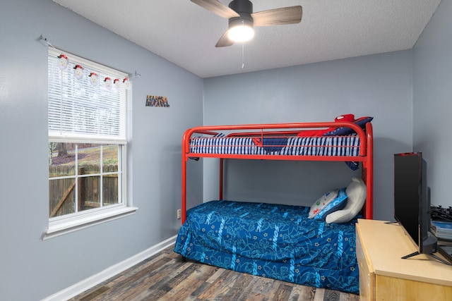 bedroom featuring ceiling fan, dark hardwood / wood-style flooring, and a textured ceiling