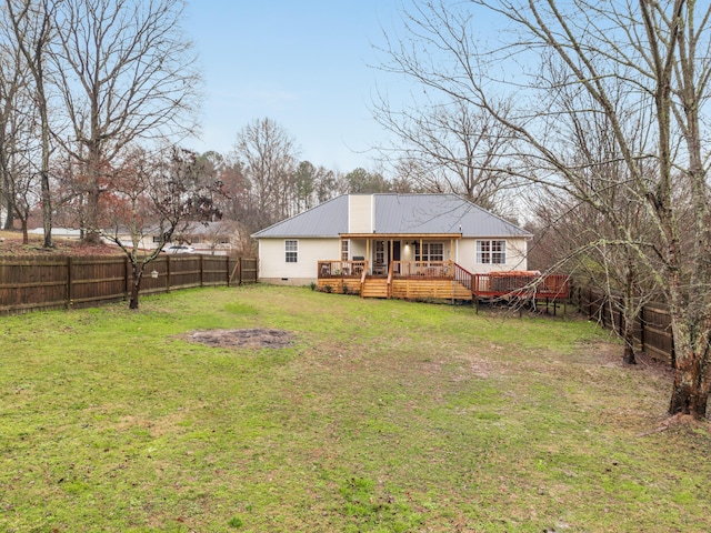 rear view of house featuring a deck and a lawn